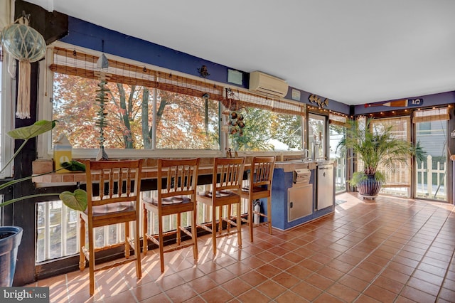 sunroom featuring a healthy amount of sunlight and a wall mounted air conditioner