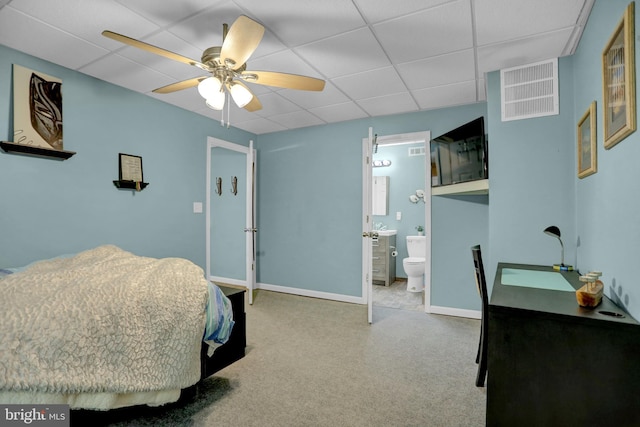 bedroom with a paneled ceiling, ensuite bathroom, and ceiling fan