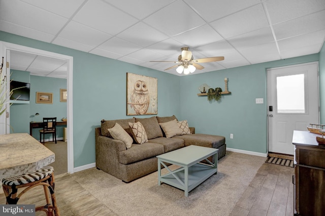 living room with a paneled ceiling, light wood-type flooring, and ceiling fan