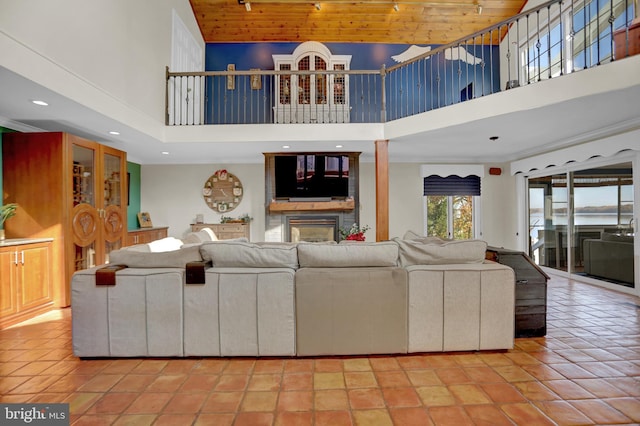 tiled living room featuring wooden ceiling and a high ceiling