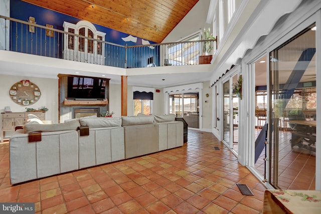 tiled living room with high vaulted ceiling, wooden ceiling, and a fireplace