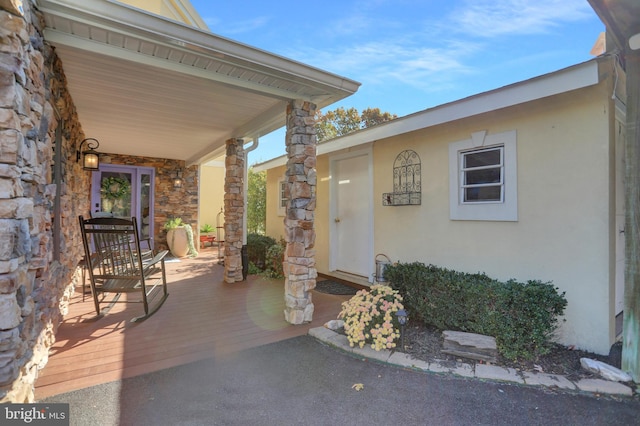 view of exterior entry featuring covered porch