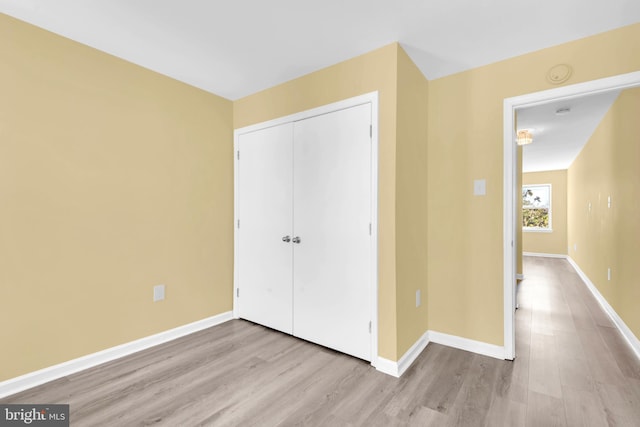 unfurnished bedroom featuring a closet and light hardwood / wood-style floors