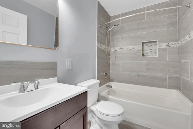 full bathroom with vanity, toilet, and tiled shower / bath combo