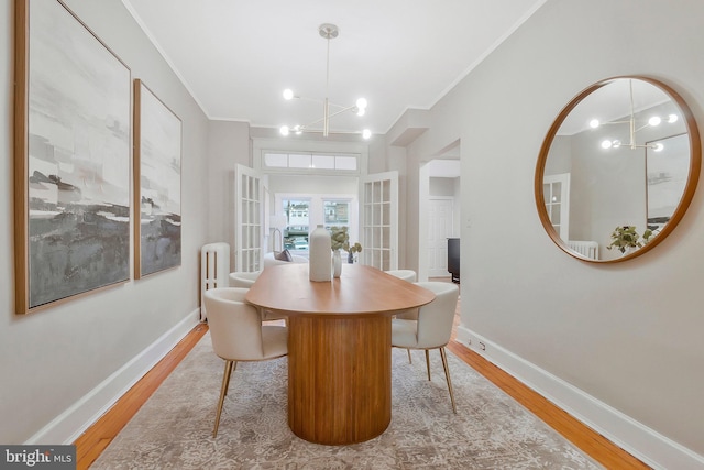 dining space featuring hardwood / wood-style floors, a notable chandelier, and ornamental molding