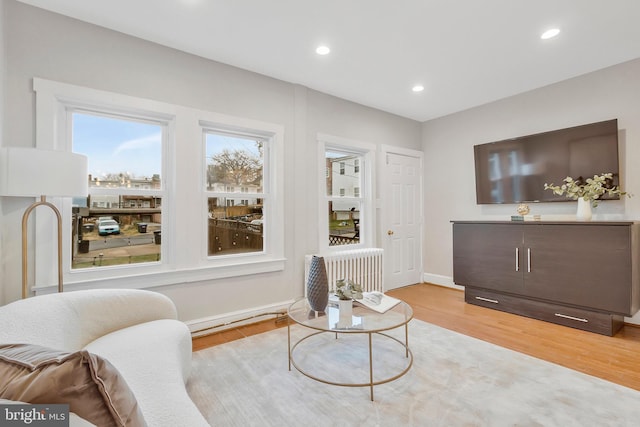 sitting room featuring radiator heating unit and light hardwood / wood-style flooring