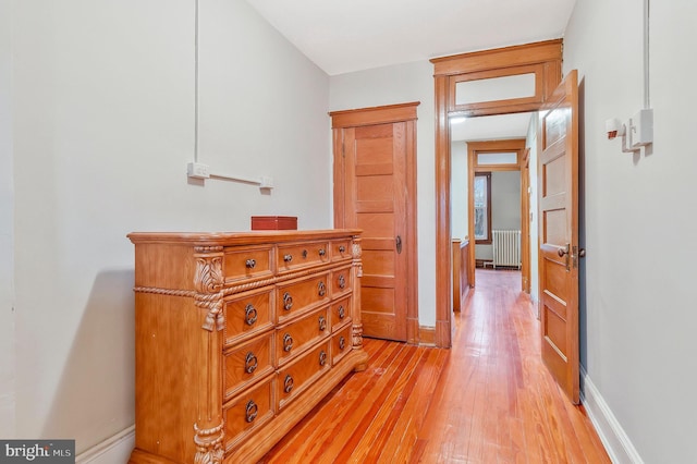 hall with light wood-type flooring and radiator heating unit