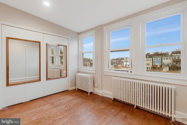 unfurnished sunroom featuring radiator and lofted ceiling