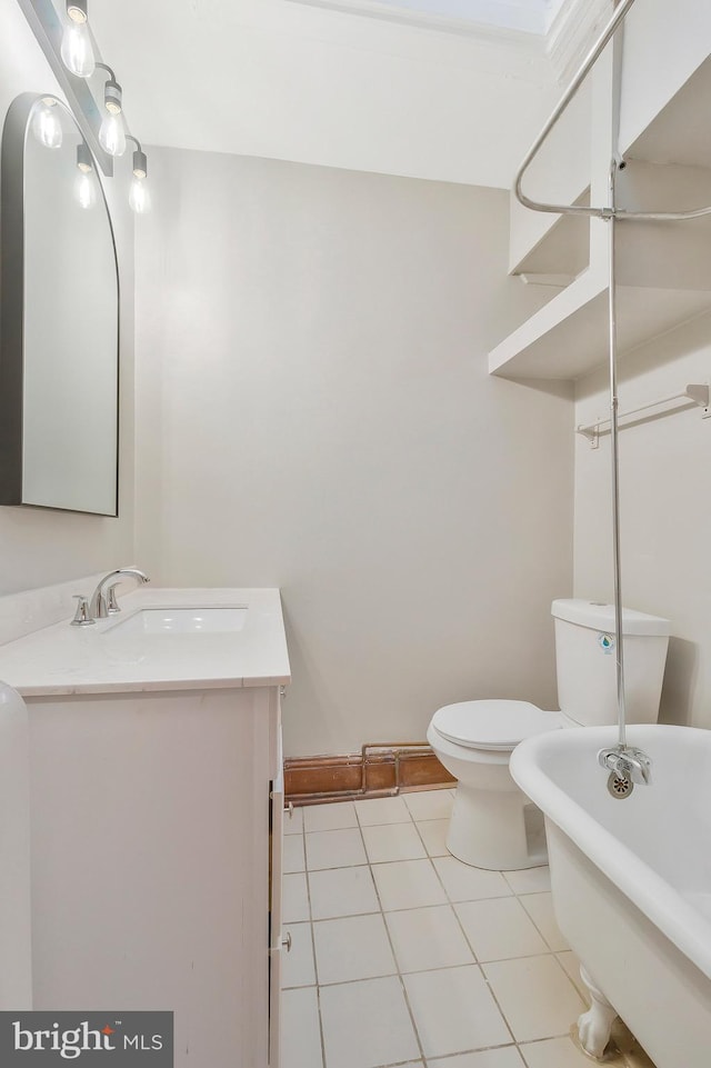 bathroom with tile patterned floors, toilet, a bathing tub, and vanity