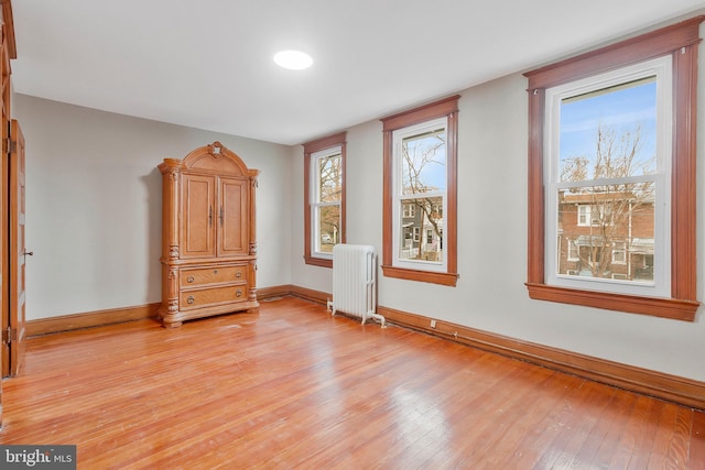 unfurnished bedroom featuring light wood-type flooring and radiator