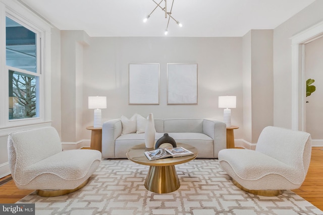 living area featuring a notable chandelier and light hardwood / wood-style flooring