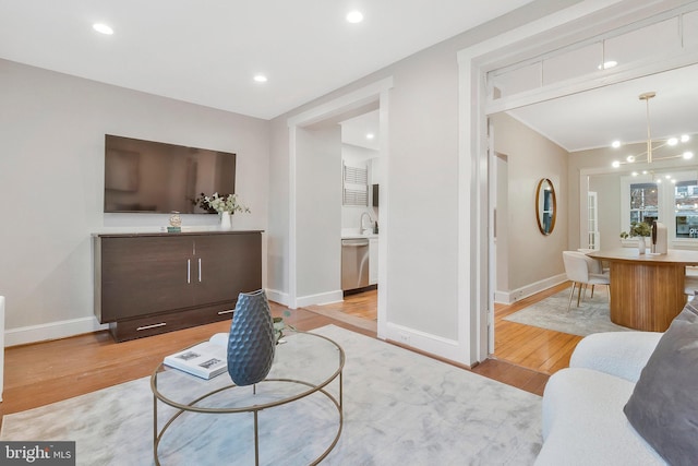 living room featuring light hardwood / wood-style floors, sink, and a chandelier