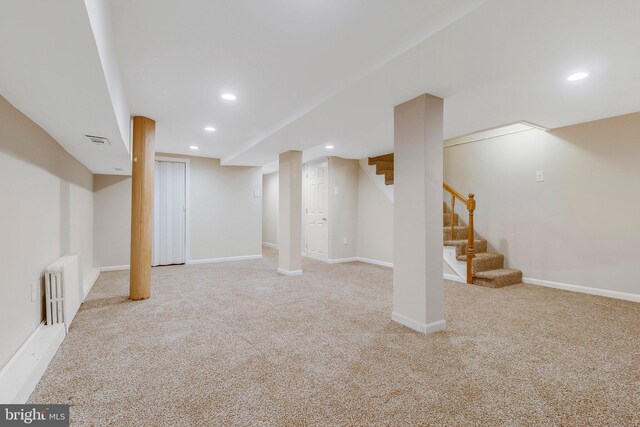 basement with light colored carpet and radiator heating unit