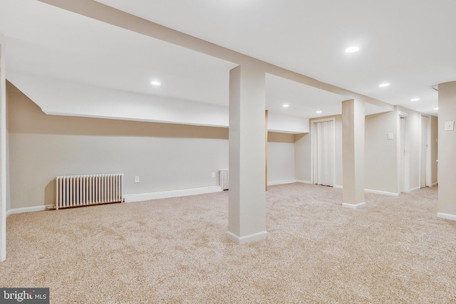 basement with radiator and light carpet