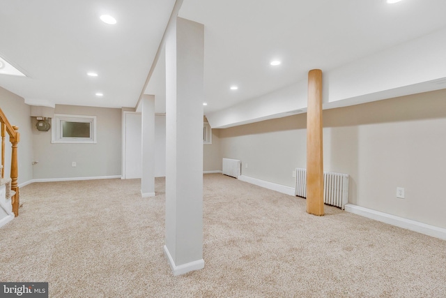 basement featuring radiator and light colored carpet