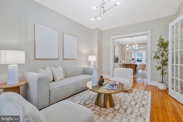 living room with hardwood / wood-style floors and an inviting chandelier