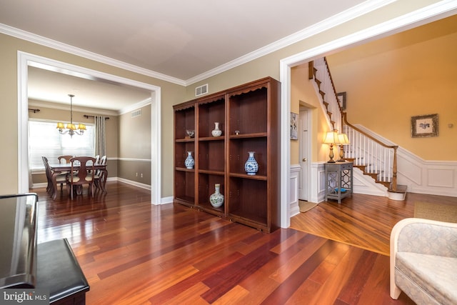 interior space featuring ornamental molding, an inviting chandelier, and dark hardwood / wood-style floors