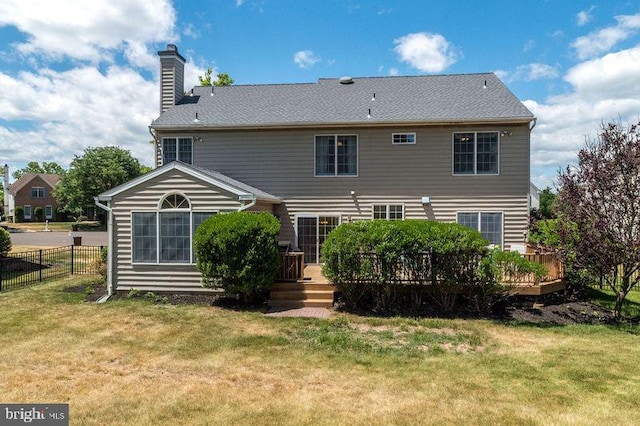 rear view of property with a yard and a deck