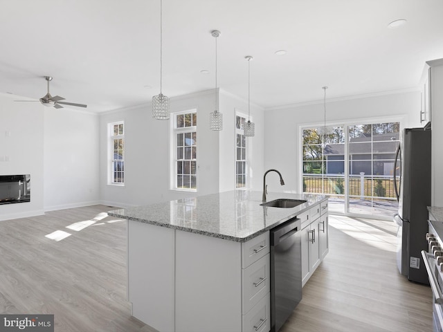 kitchen featuring sink, appliances with stainless steel finishes, hanging light fixtures, and a healthy amount of sunlight