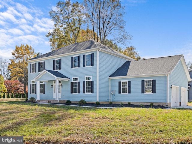 colonial-style house with a front yard and a garage