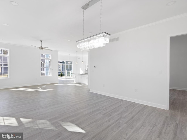 unfurnished living room with ornamental molding, light hardwood / wood-style flooring, and ceiling fan