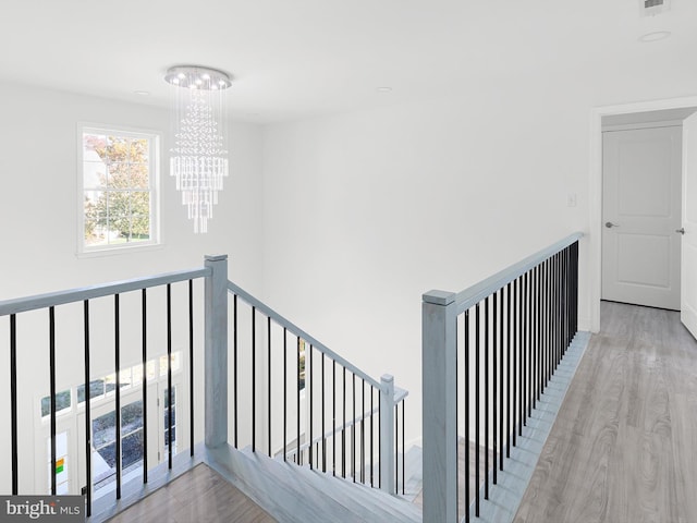 staircase featuring a chandelier and wood-type flooring