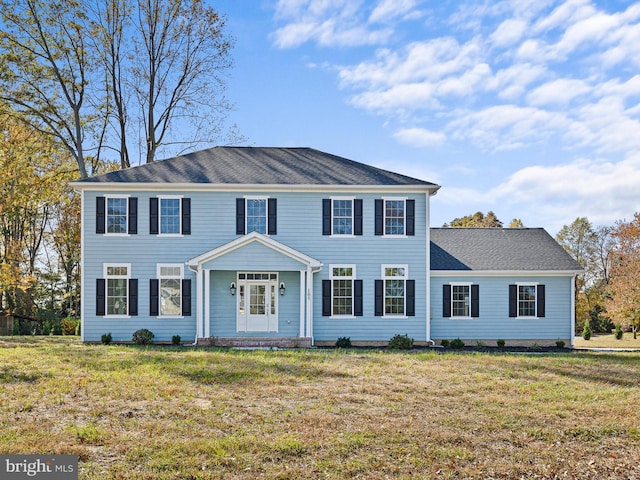 colonial home featuring a front lawn