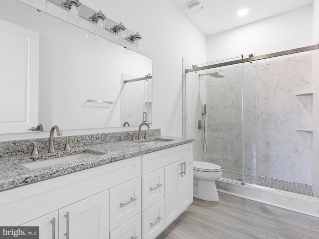 bathroom with vanity, hardwood / wood-style flooring, toilet, and a shower with door