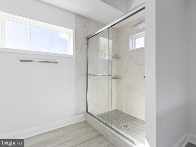 bathroom featuring plenty of natural light, an enclosed shower, and hardwood / wood-style floors