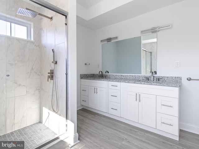 bathroom with a shower with door, hardwood / wood-style flooring, and vanity