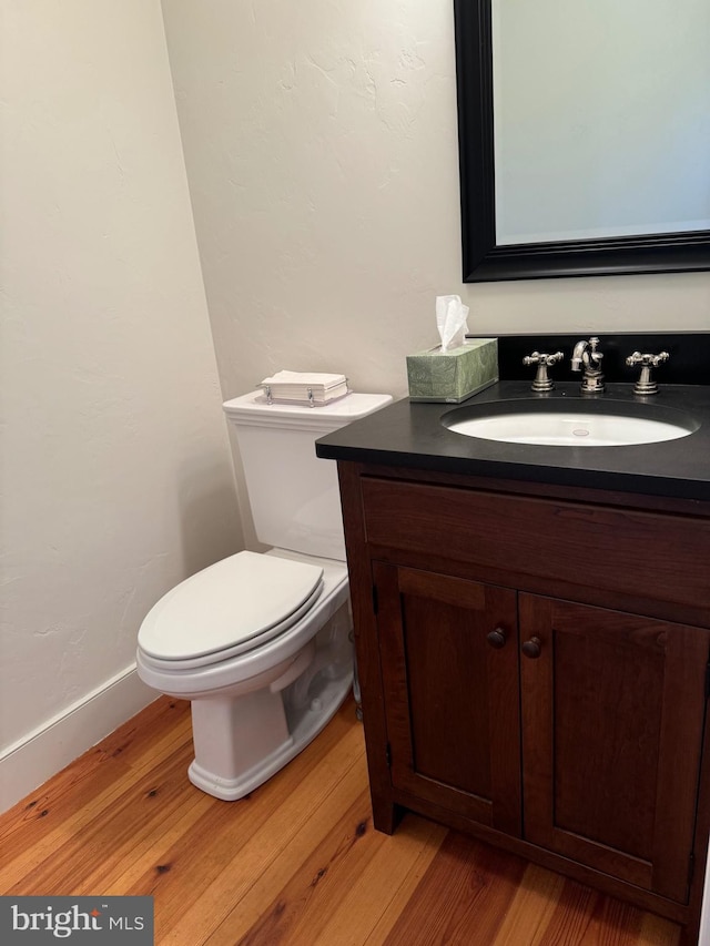 bathroom with vanity, toilet, and hardwood / wood-style flooring