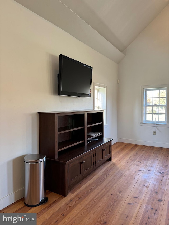 unfurnished living room with lofted ceiling and light wood-type flooring