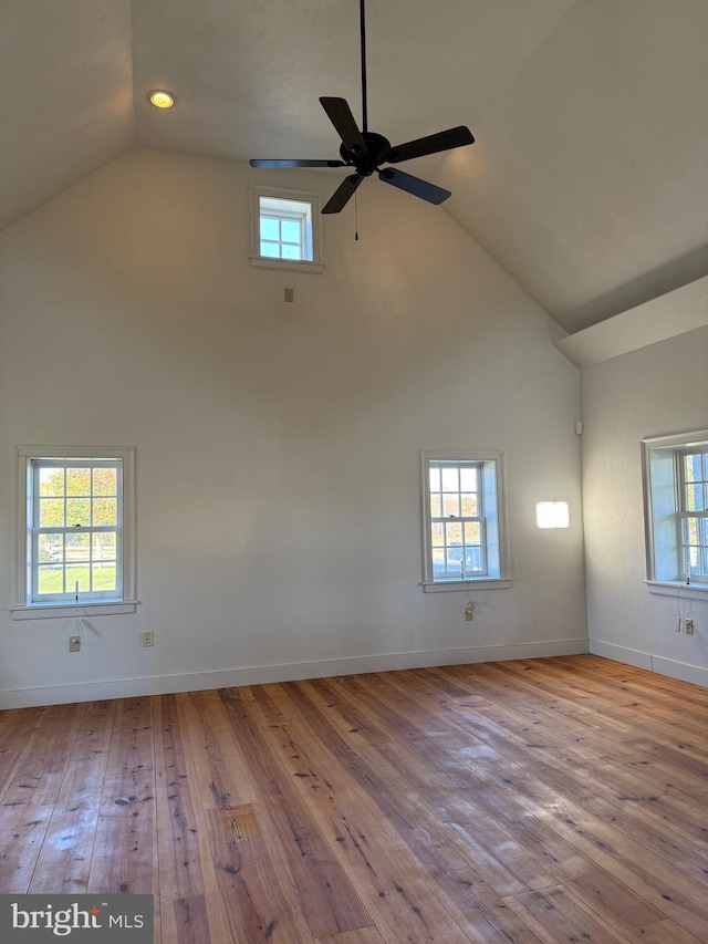 empty room featuring light hardwood / wood-style flooring, a healthy amount of sunlight, ceiling fan, and vaulted ceiling