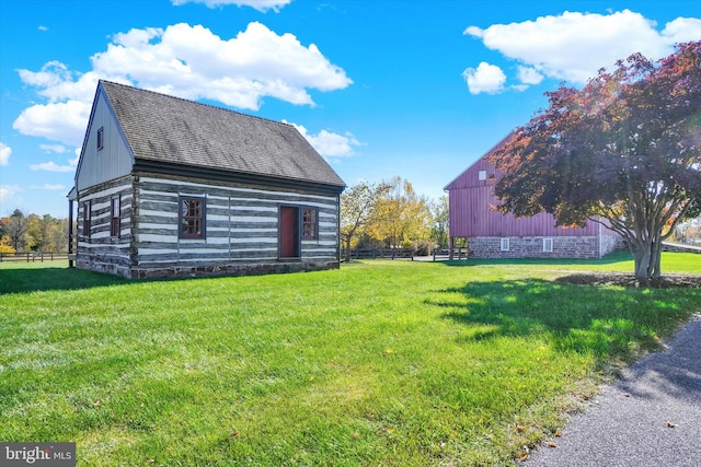 view of side of property with a lawn and an outbuilding