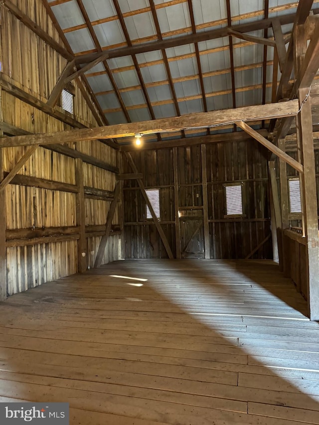 interior space featuring hardwood / wood-style flooring, high vaulted ceiling, and wood walls