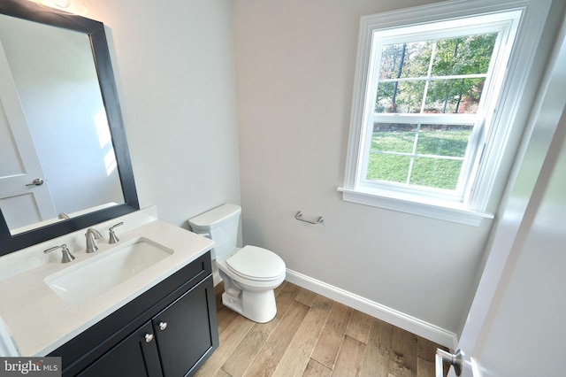 bathroom featuring toilet, hardwood / wood-style flooring, and vanity