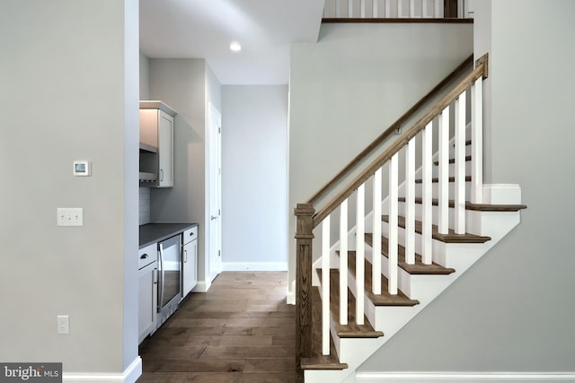 stairs featuring wine cooler and wood-type flooring