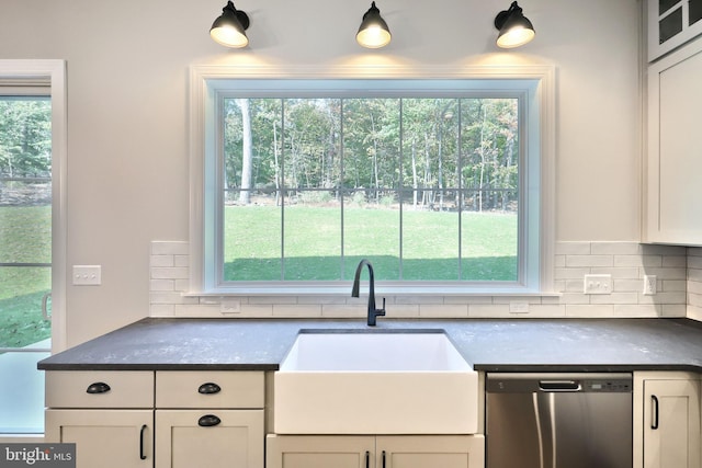 kitchen with stainless steel dishwasher, sink, decorative backsplash, and a wealth of natural light