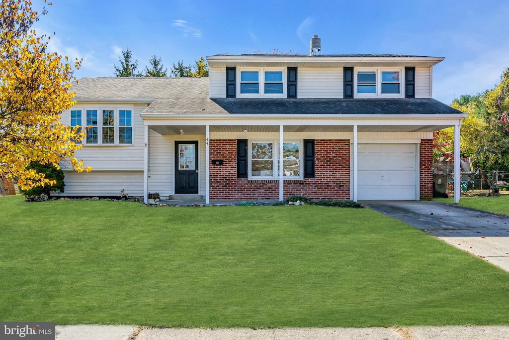 tri-level home featuring a front yard and a garage