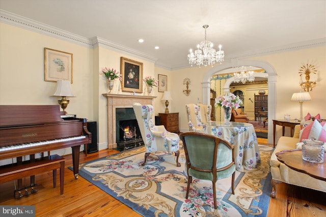 interior space featuring a fireplace, hardwood / wood-style floors, a chandelier, and crown molding