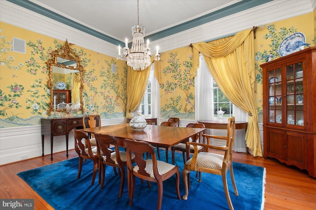 dining area with a chandelier, crown molding, and wood-type flooring