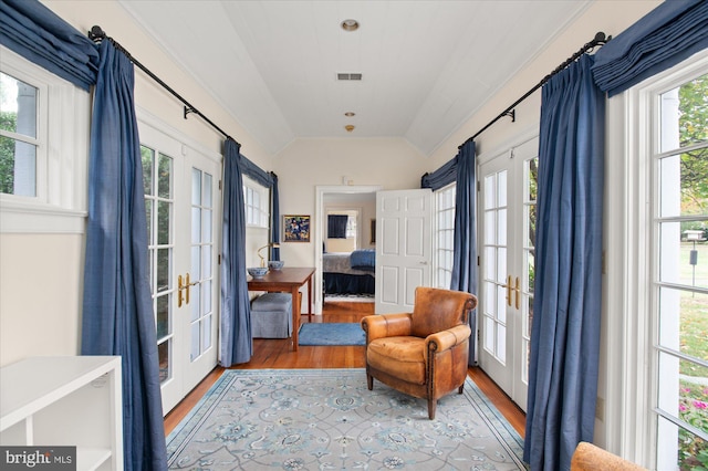 living area featuring french doors, light wood-type flooring, plenty of natural light, and lofted ceiling