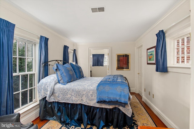 bedroom with hardwood / wood-style floors and ornamental molding