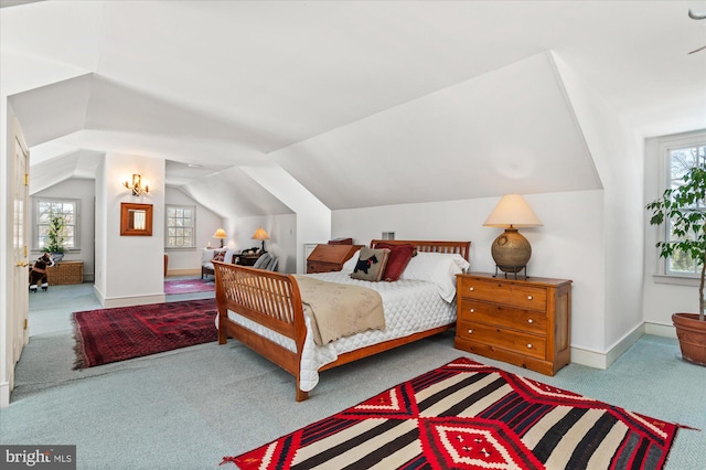 bedroom featuring light carpet, multiple windows, and lofted ceiling