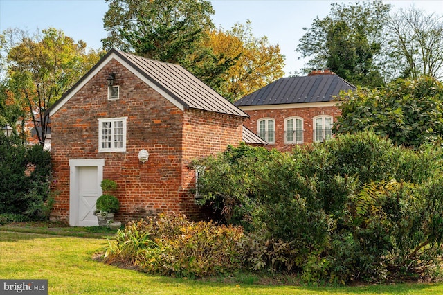 view of side of home with a yard