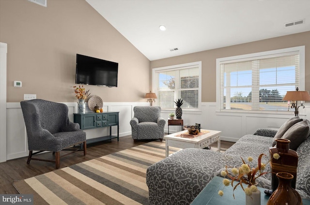 living area with high vaulted ceiling and dark hardwood / wood-style flooring