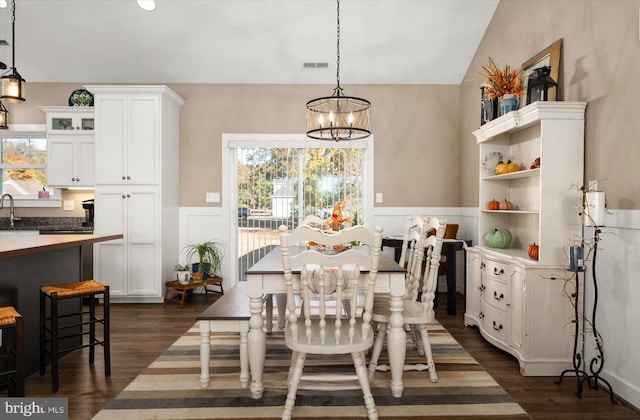 dining area featuring a notable chandelier, a healthy amount of sunlight, and dark hardwood / wood-style flooring