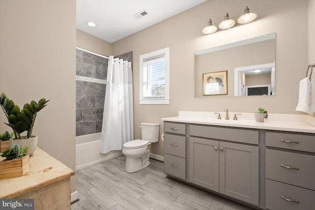 full bathroom with vanity, toilet, wood-type flooring, and shower / tub combo