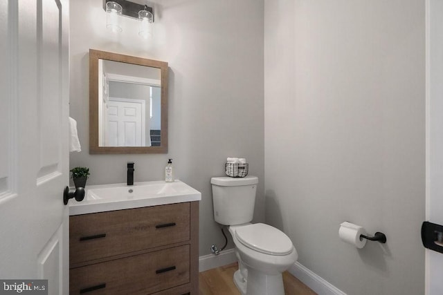 bathroom featuring hardwood / wood-style flooring, vanity, and toilet