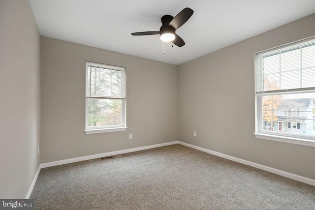 carpeted spare room with ceiling fan